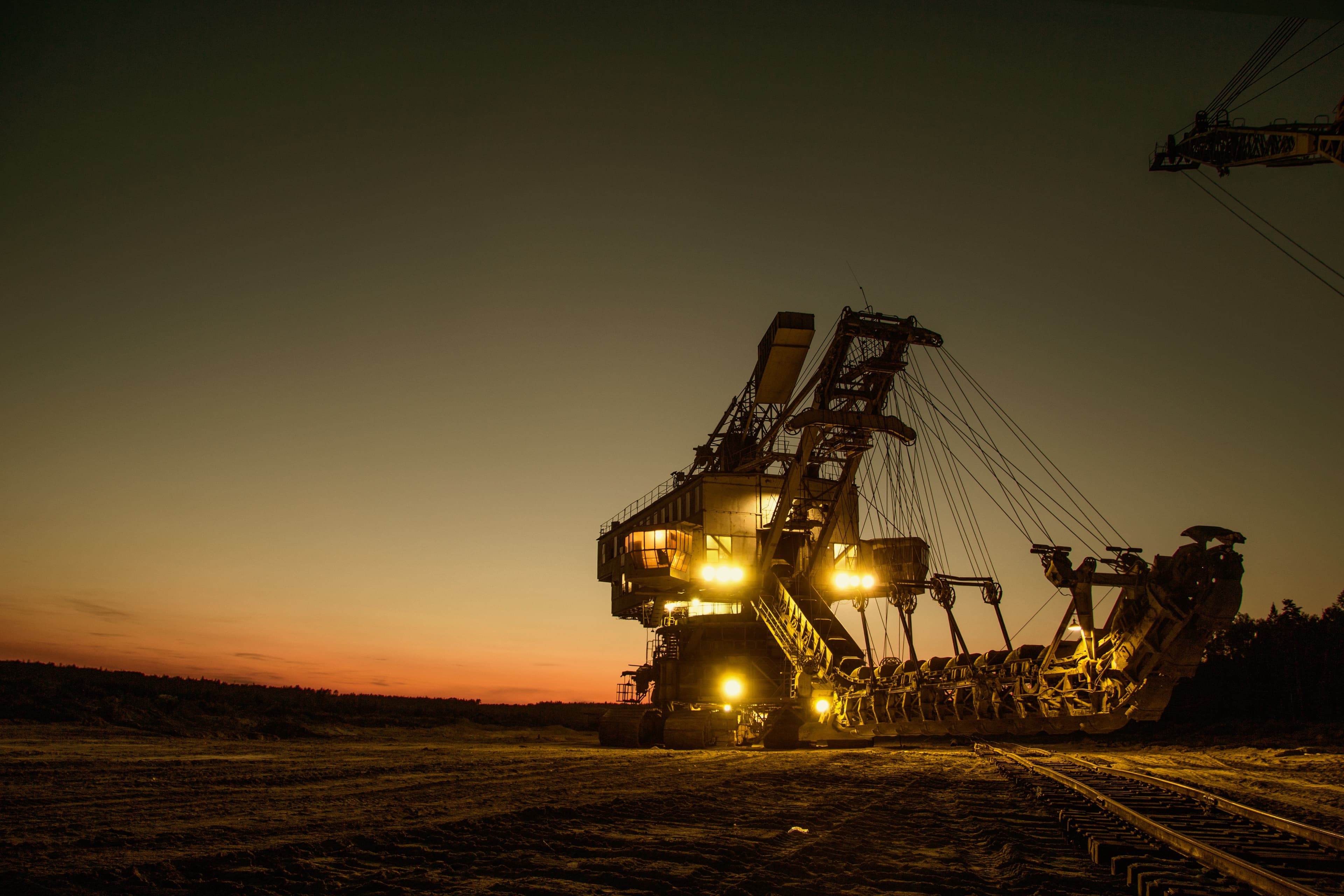 Open-pit mining equipment at sunset